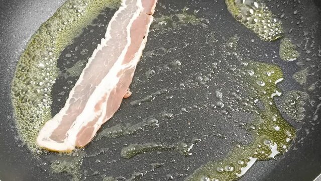 tranches de bacon, en cuisson dans une po&ecirc;le, en gros plan