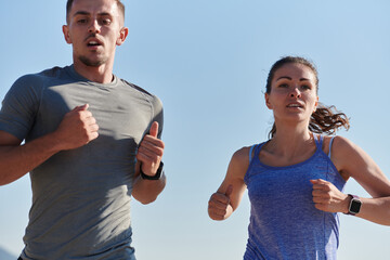 Energized by the beauty of nature, a couple powers through their morning run, their bodies and...