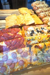 Various types of pizza slices displayed on a wooden board.