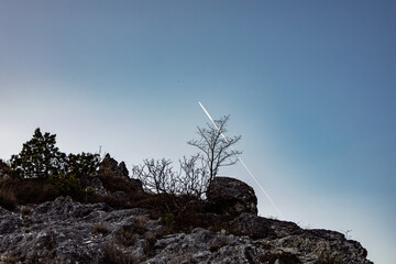Aircraft trail, blue sky and rock