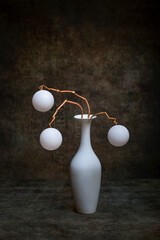 Still life with white balls in a white vase