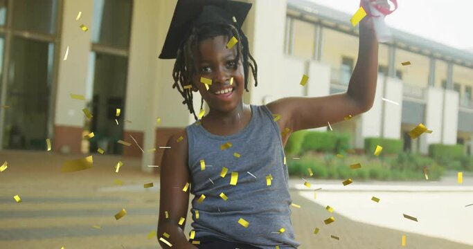 Animation of gold confetti over happy african american schoolboy with diploma wearing mortarboard