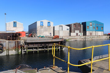 Fototapeta na wymiar Harbourside/ quayside lined with industrial buildings 