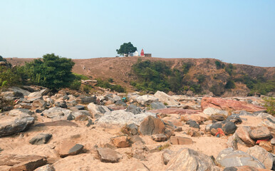 A Hindu temple with on hilltop of Chota Nagpur plateau in Simultala, with almost dried-up stream of Telwa river flowing through rocky terrain of Dharara waterfall.