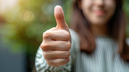 Empowerment at hand: An extreme close-up captures a woman's confident thumb-up gesture, radiating positivity and success