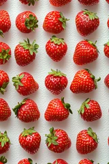 Schilderijen op glas Fresh strawberries arranged in a pattern on a white surface with the tops facing the viewer © SHOTPRIME STUDIO