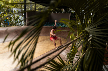 Skateboarder mid-turn in a leafy skatepark, dynamic action
