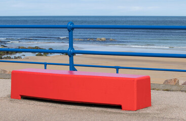 A bench on the promenade at the beach - obrazy, fototapety, plakaty