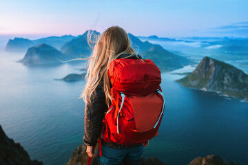 Woman with backpack traveling in Lofoten islands hiking solo in Norway healthy lifestyle female tourist in mountains enjoying sea aerial view outdoor summer vacations adventure weekend getaway