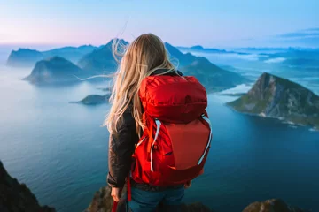 Fototapete Woman with backpack traveling in Lofoten islands hiking solo in Norway healthy lifestyle female tourist in mountains enjoying sea aerial view outdoor summer vacations adventure weekend getaway © EVERST
