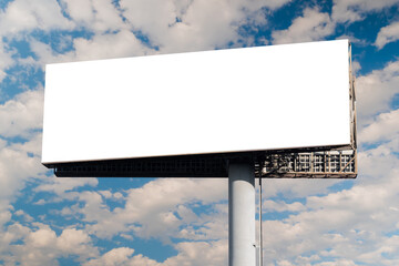 Blank wide horizontal white billboard mockup or large display against the blue sky with white clouds. Mock up, copy space, outdoor advertising, marketing, white screen and template concept