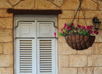 Stone Wall with Window Shutters and Hanging Flower Basket