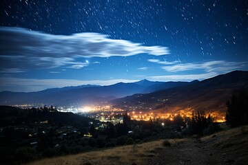 City illuminated in mountains under starry sky, with natural landscape