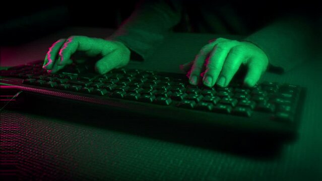 Primer plano de las manos escribiendo en el teclado. Luces de ne&oacute;n verdes y rosas iluminan los laterales. glitch. ciberpunk. 60 fps.