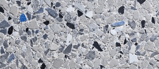 A close up of a concrete surface covered in small rocks, creating a textured pattern. The rocks contrast with the smooth concrete, creating an interesting landscape