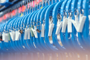 A metal roller rail in a textile factory industrial setting. Metal oil hangers on metal rollers....