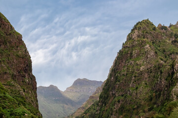 Scenic view of rugged mountain peaks of Madeira island, Portugal, Europe. Steep hill landscape in remote wilderness. Majestic ridges and rock formations formed by natural forces. Clouds accumulating