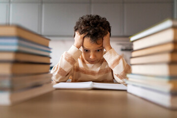 Overwhelmed black boy looking stressed while study at home - obrazy, fototapety, plakaty