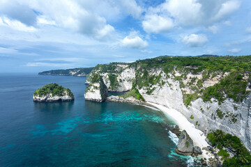 Fototapeta na wymiar Landscape of sunny day with turquoise ocean, blue sky and mountains. View of Diamond beach, Nusa Penida, Bali island, Indonesia. Wallpaper background. Natural scenery.