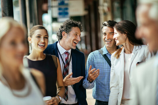 Diverse business people laughing while walking to work