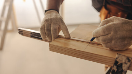 Skilled contractor measuring wood for trim work while renovating a home