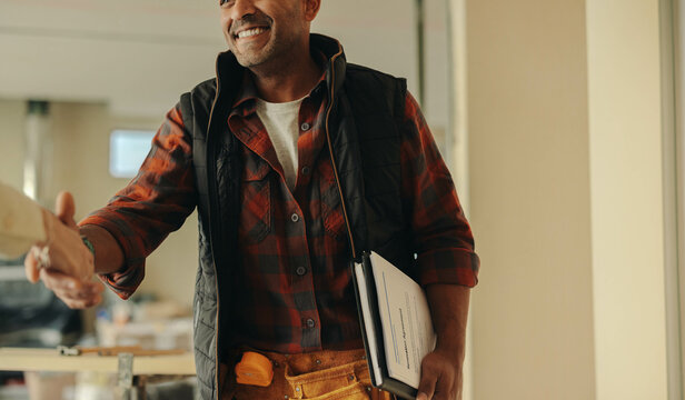Building a successful partnership: Contractor and homeowner shake hands on a renovation deal