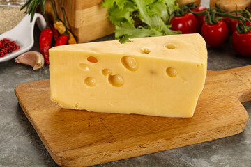 Swiss Maasdam cheese triangle over board