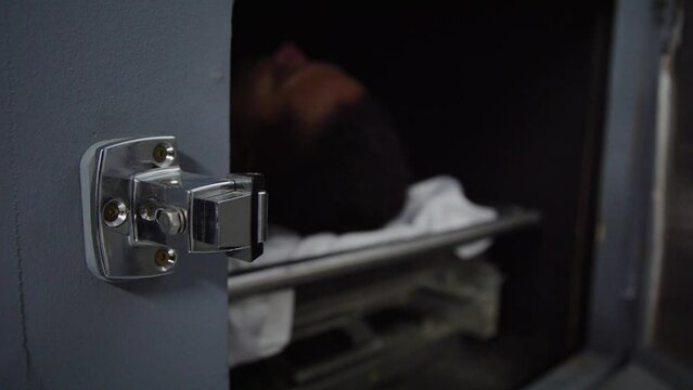 Corpse in a morgue being removed by doctor