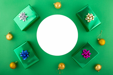 Elegant New Year arrangement in opulent hues. Overhead shot of luxurious gifts and presents on green backdrop, offering circe for festive wishes or promo.