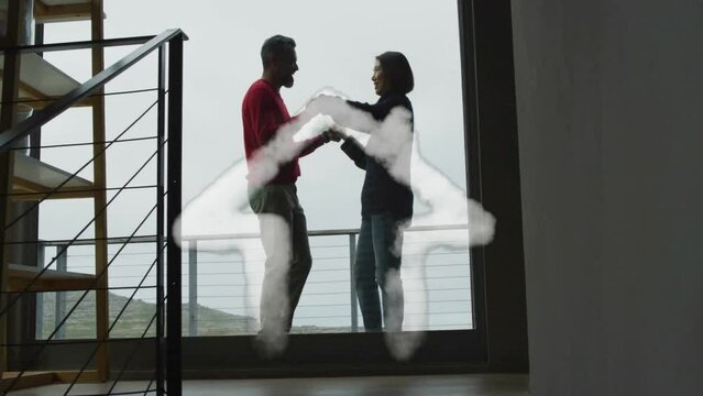 Animation of house shape over diverse couple dancing on balcony