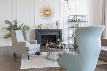 Modern luxury stylish apartment interior in pastel colors. a very bright room with huge windows filled with daylight. white walls, wooden parquet floors and a dark marble fireplace