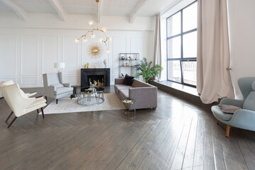 Modern luxury stylish apartment interior in pastel colors. a very bright room with huge windows filled with daylight. white walls, wooden parquet floors and a dark marble fireplace
