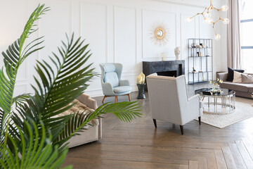 Modern luxury stylish apartment interior in pastel colors. a very bright room with huge windows filled with daylight. white walls, wooden parquet floors and a dark marble fireplace