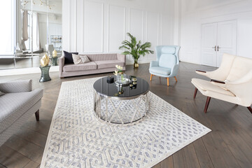 Modern luxury stylish apartment interior in pastel colors. a very bright room with huge windows filled with daylight. white walls, wooden parquet floors and a dark marble fireplace