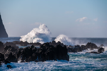 Strong waves smashing against jagged volcanic rocks on pristine coastline of coastal town Porto...