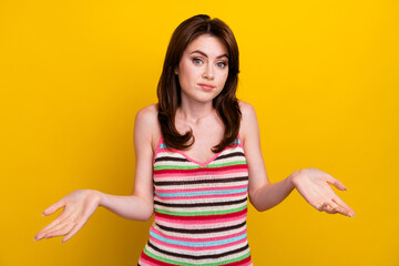 Photo of clueless guilty adorable girl with stylish hairdo wear striped tank shrugging shoulders...