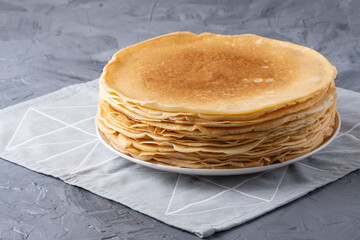 A stack of thin pancakes on a grey table , with copy space for text