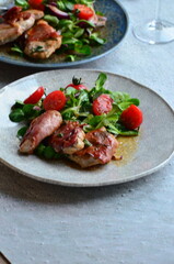 beautiful background of food served on a rustic plate, italian cuisine, veal saltimbocca, mixed salad, close up view,