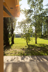 Sunshine Peeking Through Trees Near Cozy Home Porch