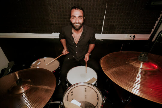 Male drummer playing in a music band setup