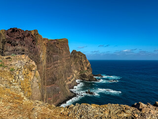 Naklejka premium Panoramic view of majestic Atlantic Ocean coastline at Ponta de Sao Lourenco peninsula, Canical, Madeira island, Portugal, Europe. Coastal hiking trail along steep rocky rugged cliffs. Sea breeze. Awe