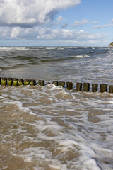 Scenic view of wooden breakwater with Green algae in foaming water of Baltic Sea, Miedzyzdroje, Wolin Island, Poland