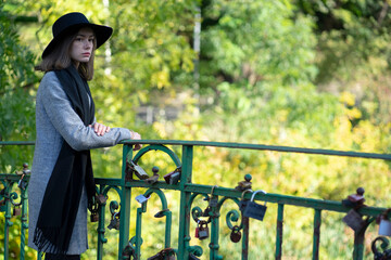 Girl in a hat standing on the bridge of lovers.