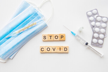 Stop coronavirus inscription. Preparing for vaccination against covid. Syringe, vaccine, pills, medical mask. A new strain of the virus.