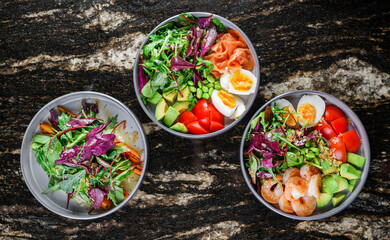 Buddha bowls with salads with shrimps and salmon fish ,arugula, spinach, avocado, tomatoes, green...