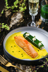 Steak fillet salmon with red caviar fish, sauce and herbs on plate on marble background with drinks. Healthy seafood, top view