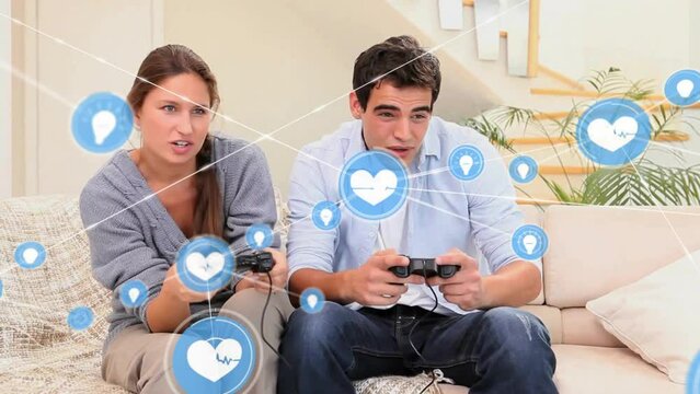 Animation of network of connections with icons over caucasian couple playing video games