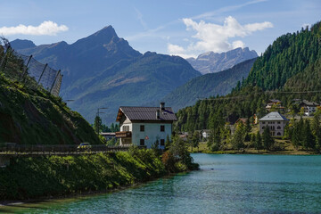 Touristic view of Alleghe resort in the italian Dolomites on bright autumn day, Europe