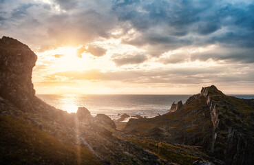 Dramatic scene with big rocks, sea, sunbeam and sundown