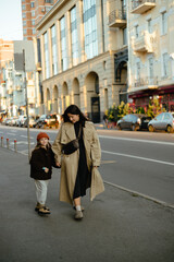 29.01.24 Kyiv, Ukraine: A stylish mother and daughter stroll through the evening streets of a big city